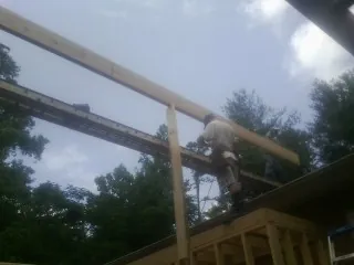 Carpenter setting a ridge beam over a new addition frame — Ice Dam Removal by Roofing Brothers in North Street