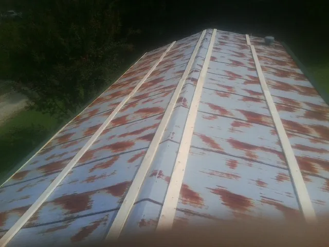 Rusted metal roof panels with new wood purlins before replacement — Storm Damage Roof Repair in North Street by Roofing Brothers