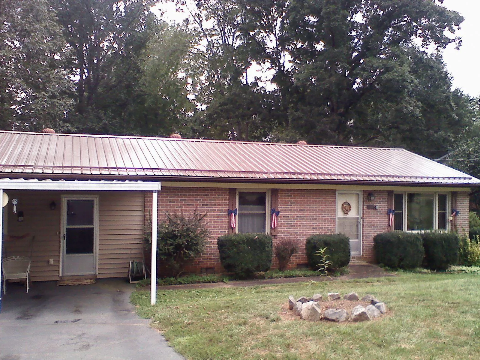 Bronze metal roof and carport on a brick ranch home — Roof Repair work by our crew in North Street